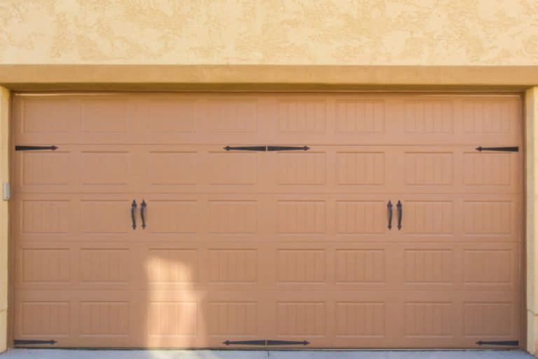 What factors influence the weight of a garage door?