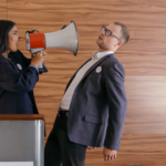 A woman using a megaphone to scream at a man