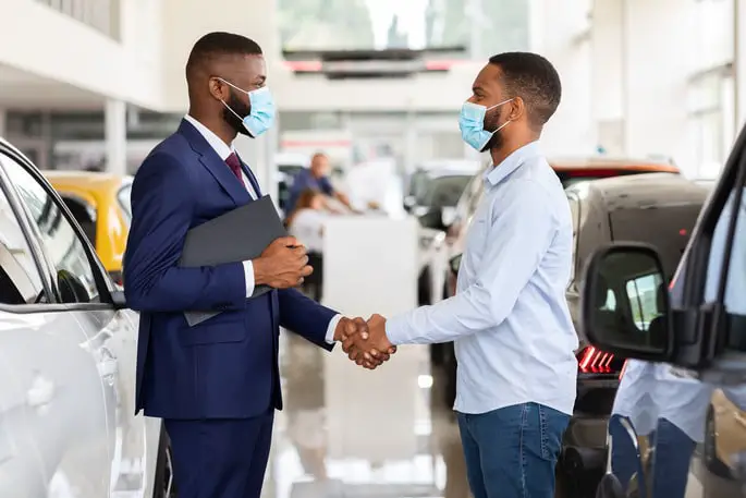 car-dealership-black-salesperson-in-medical-mask-2022-01-19-00-11-06-utc-5142d877