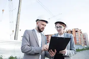 Screenshot 2023-05-24 at 16-56-02 Free Photo Young female and male architect wearing hard hat looking at clipboard