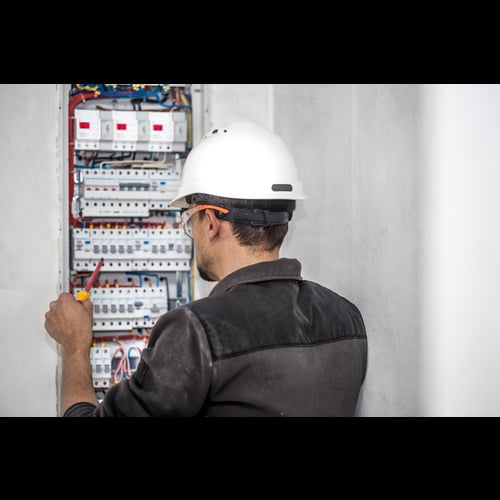man-electrical-technician-working-switchboard-with-fuses-installation-connection-electrical-equipment (1)
