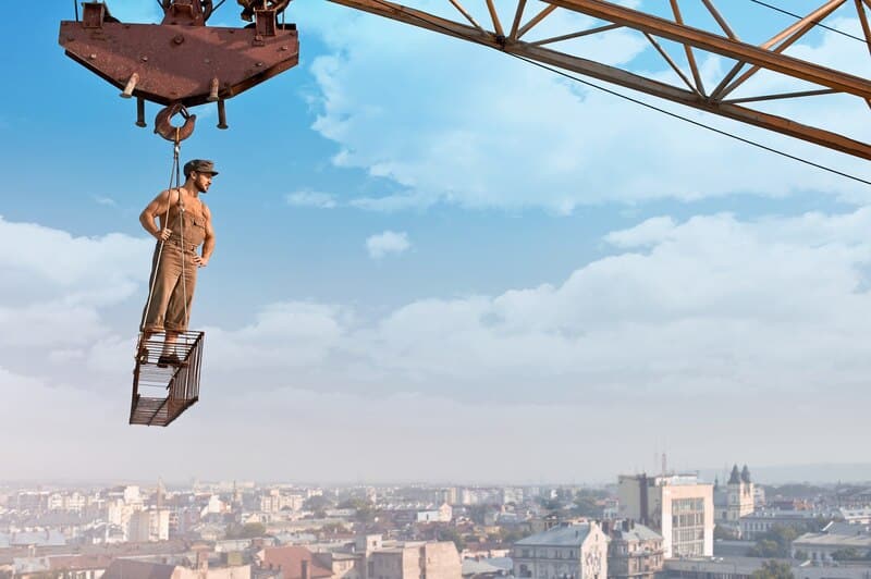 ready-day-low-angle-portrait-young-muscular-retro-builder-posing-crossbar-hanging-from-crane-skyscraper_7502-8712