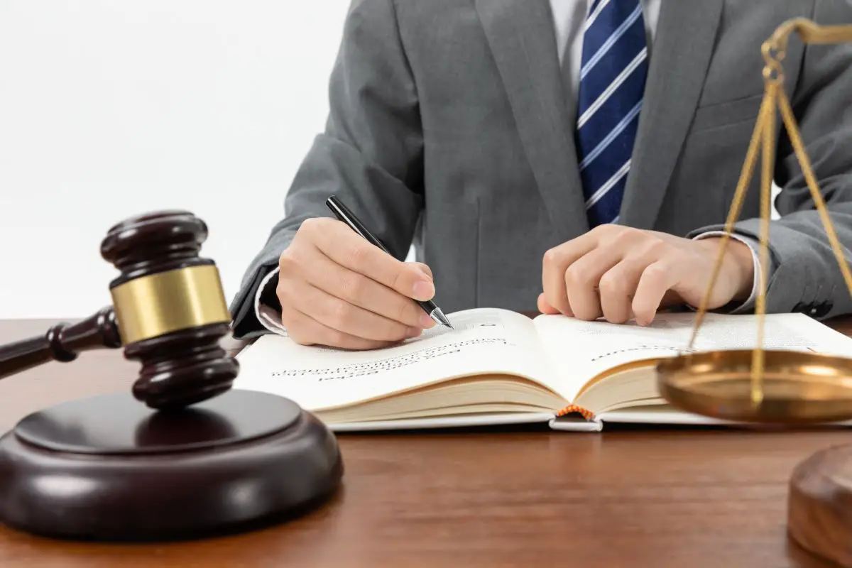 closeup-shot-person-writing-book-with-gavel-table1