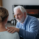 Elderly man with his hand on a woman’s shoulder