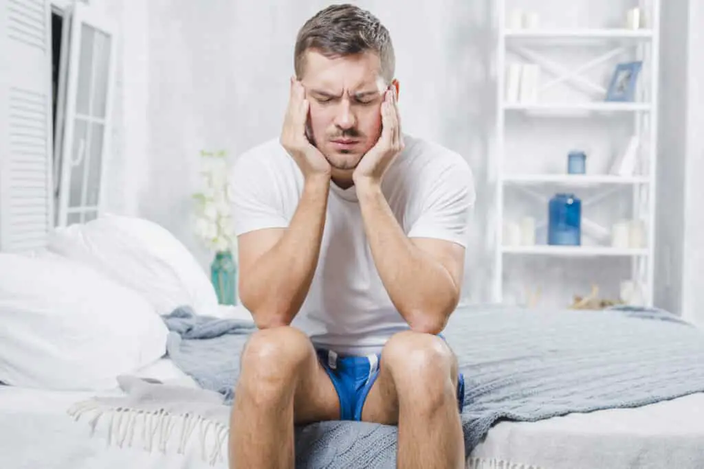 close-up-man-sitting-bed-having-headache-1024x683