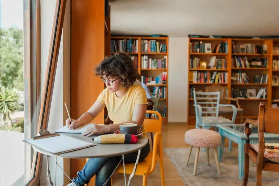 teen-girl-writing-notebook-near-window1