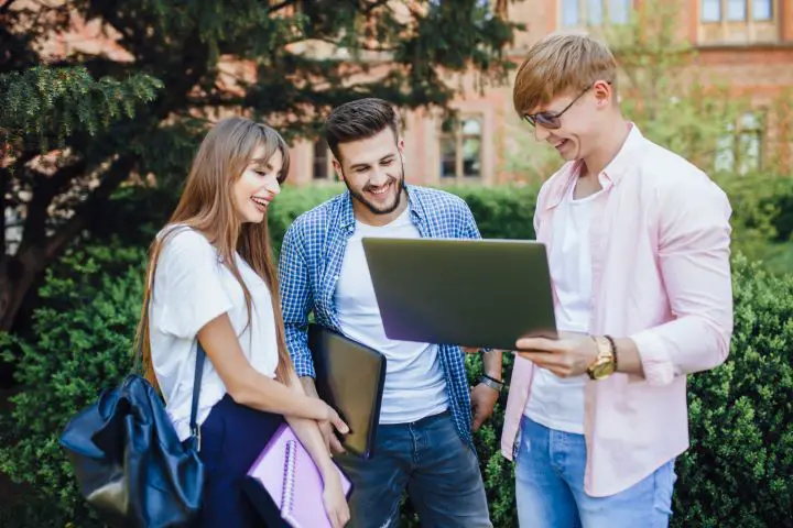 three-students-stylish-clothes-look-laptop-laugh-university-campus1